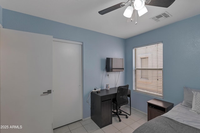 bedroom featuring light tile patterned flooring, a ceiling fan, visible vents, and baseboards