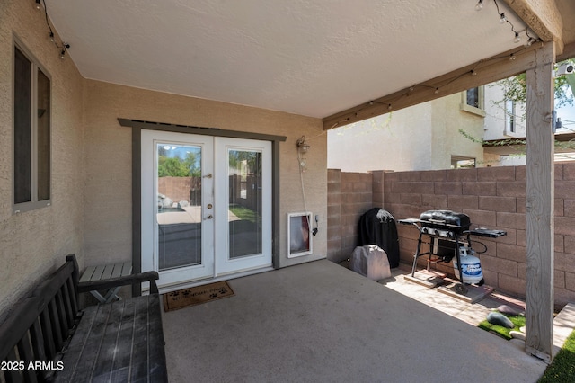 view of patio / terrace with fence, french doors, and a grill