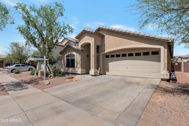 mediterranean / spanish-style house featuring concrete driveway, an attached garage, a tile roof, and stucco siding