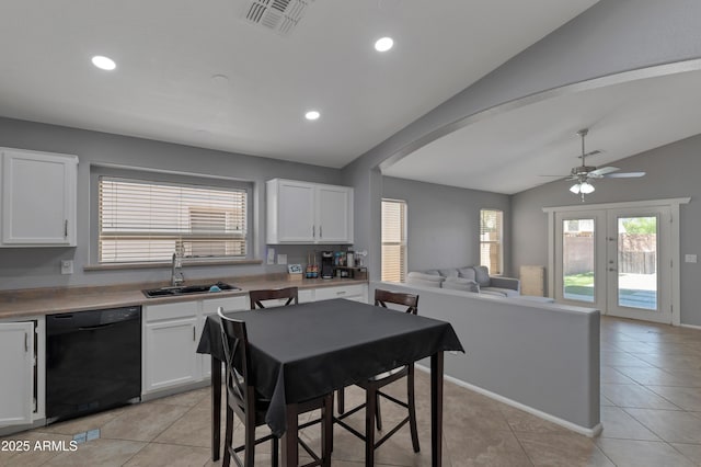 kitchen featuring lofted ceiling, open floor plan, black dishwasher, white cabinets, and a sink
