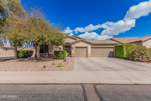 view of front of house featuring a garage, a tiled roof, concrete driveway, and stucco siding