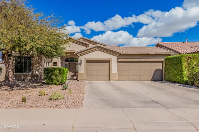 view of front of home with a tile roof, driveway, an attached garage, and stucco siding