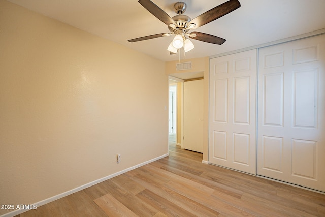 unfurnished bedroom with a ceiling fan, visible vents, baseboards, a closet, and light wood finished floors