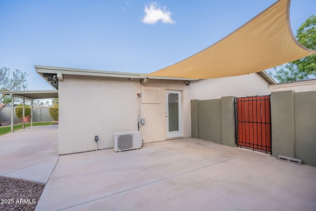 back of house with ac unit, a gate, fence, a patio area, and stucco siding