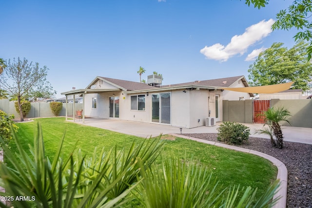 rear view of property featuring a patio, a fenced backyard, a yard, central air condition unit, and stucco siding