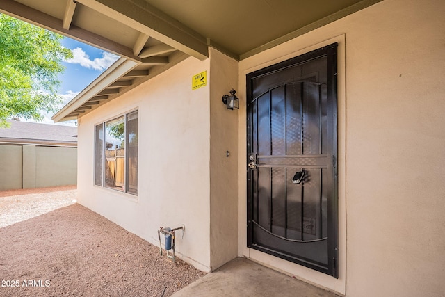 view of exterior entry with stucco siding