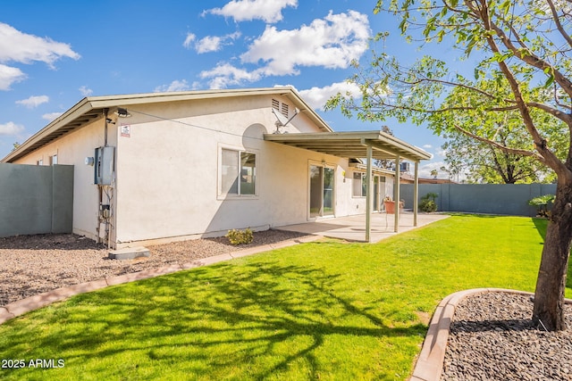 rear view of property with a patio area, a lawn, a fenced backyard, and stucco siding