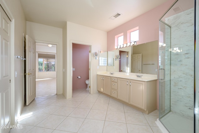 bathroom with toilet, vanity, tile patterned floors, and a shower with shower door