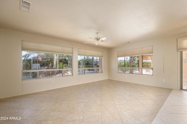 tiled spare room with ceiling fan