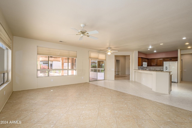 unfurnished living room with ceiling fan and light tile patterned flooring