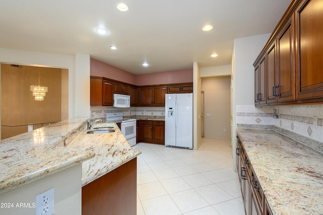 kitchen featuring white appliances, sink, decorative backsplash, light stone countertops, and kitchen peninsula