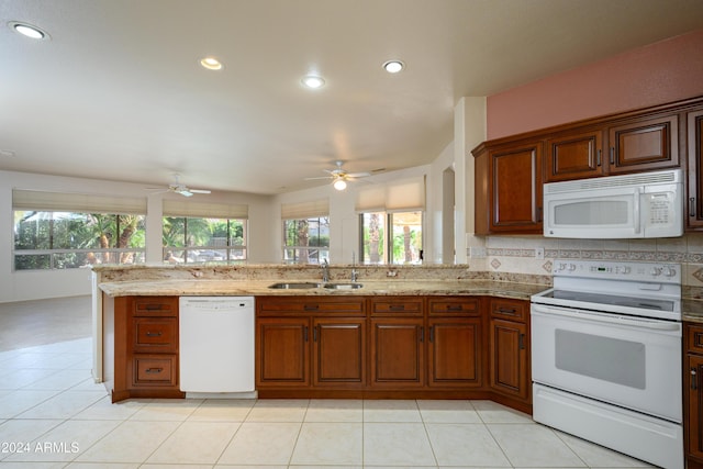 kitchen featuring light tile patterned floors, white appliances, a wealth of natural light, and sink