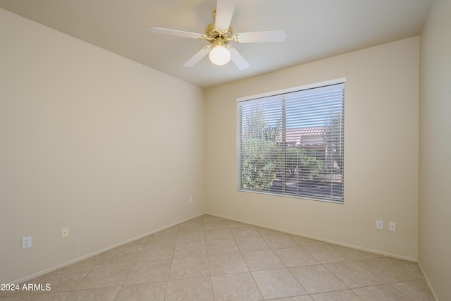 tiled spare room with ceiling fan