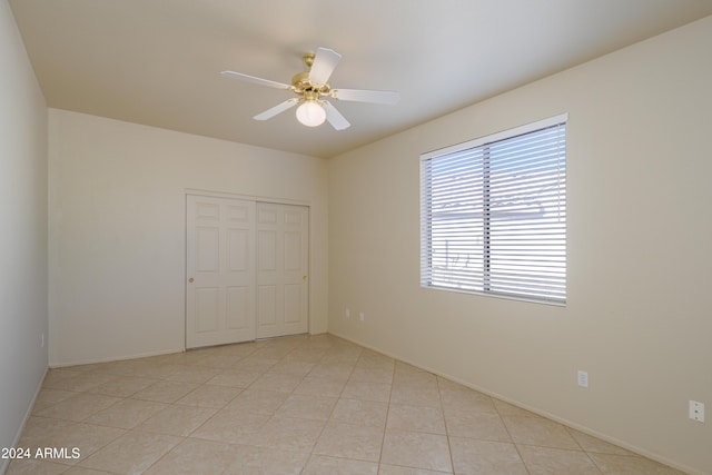 unfurnished bedroom featuring a closet, ceiling fan, and light tile patterned flooring