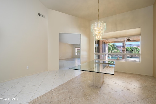 empty room with light tile patterned floors and a notable chandelier