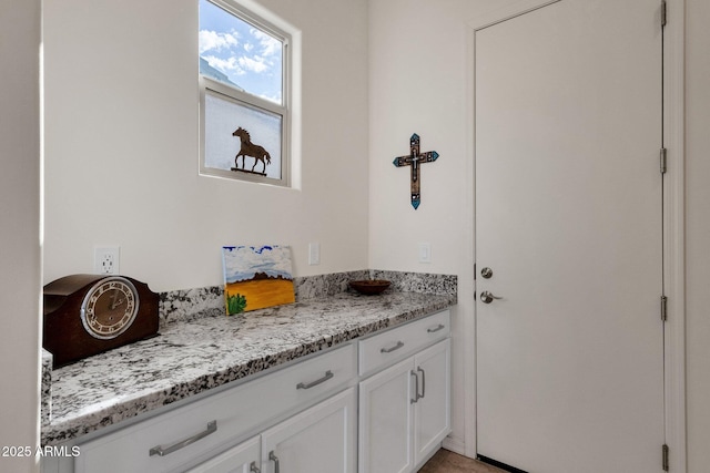 interior space with light stone counters and white cabinets