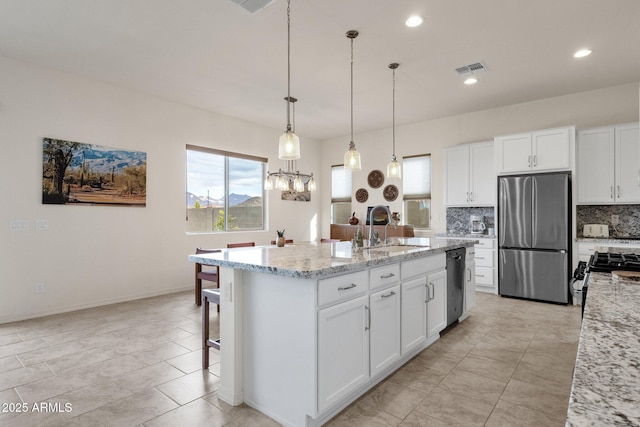 kitchen with white cabinetry, sink, stainless steel appliances, and light stone countertops