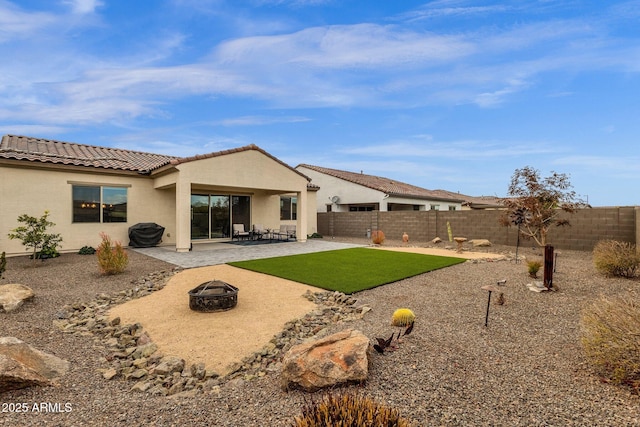 rear view of property with a patio and a fire pit