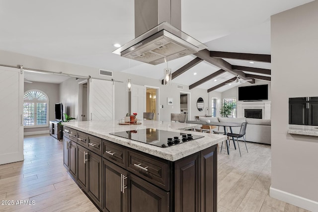 8361 E San Rafael Dr, Scottsdale, AZ 85258 - kitchen featuring black electric stovetop, a barn door, light wood-style floors, a ceiling fan, and recessed lighting