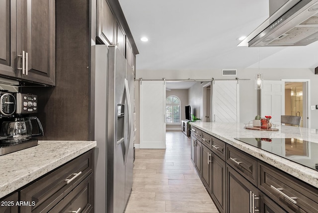 8361 E San Rafael Dr, Scottsdale, AZ 85258 - kitchen featuring stainless steel fridge, range hood, dark brown cabinetry, a barn door, and recessed lighting