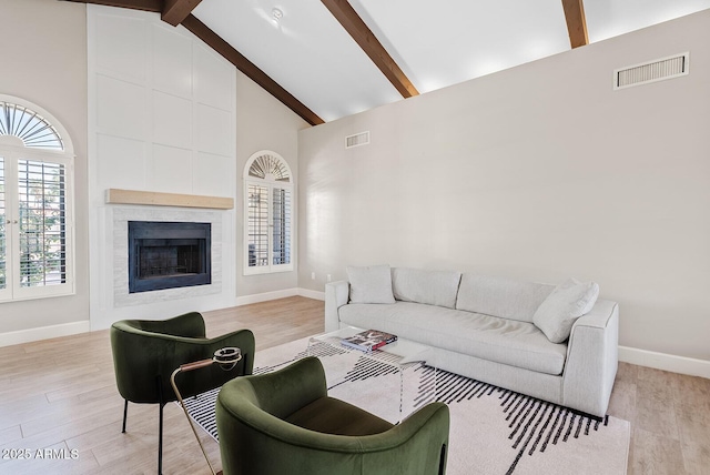 8361 E San Rafael Dr, Scottsdale, AZ 85258 - living room with high vaulted ceiling, beamed ceiling, plenty of natural light, a fireplace, and light wood-style floors