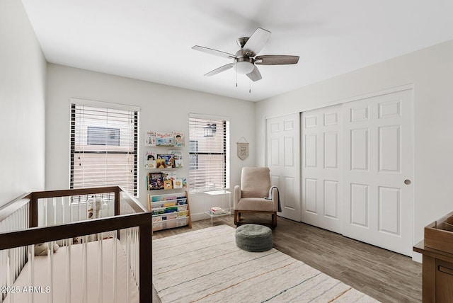 8361 E San Rafael Dr, Scottsdale, AZ 85258 - bedroom featuring wood finished floors, a closet, a nursery area, and a ceiling fan