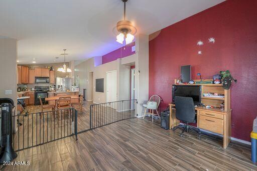 interior space featuring dark hardwood / wood-style flooring and ceiling fan with notable chandelier