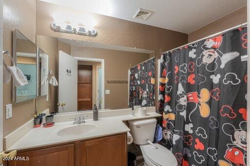 bathroom featuring a shower with shower curtain, vanity, and toilet