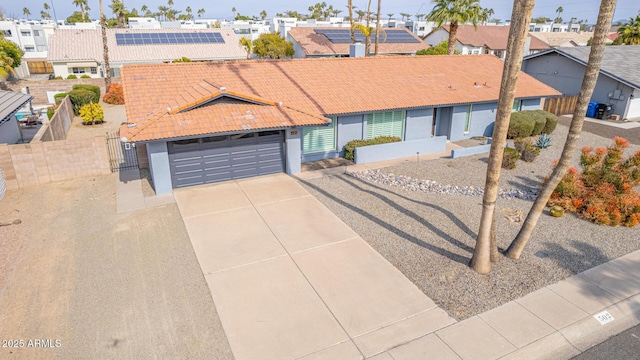 ranch-style house featuring a residential view, concrete driveway, and a tile roof