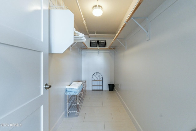 walk in closet with light tile patterned floors