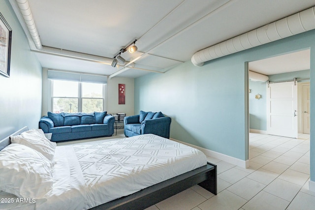 bedroom with a barn door and light tile patterned floors