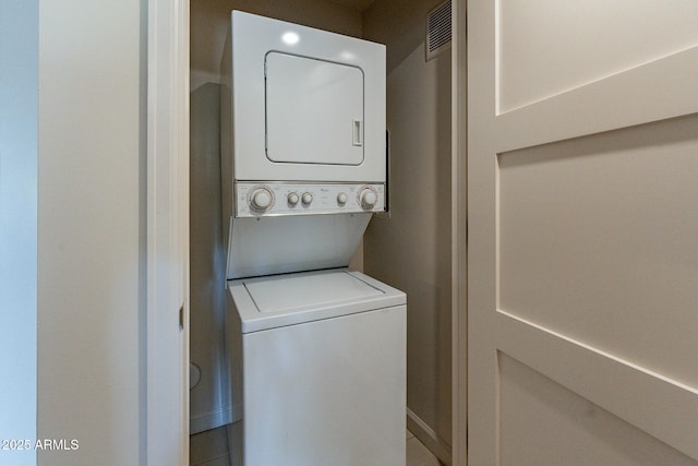 clothes washing area featuring stacked washer / dryer