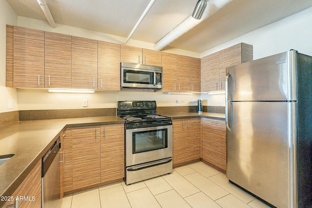 kitchen featuring beamed ceiling, appliances with stainless steel finishes, and light tile patterned floors