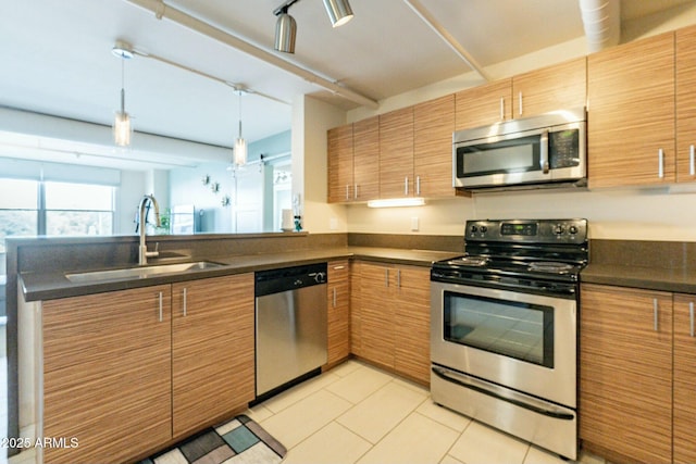 kitchen featuring light tile patterned flooring, appliances with stainless steel finishes, sink, hanging light fixtures, and kitchen peninsula