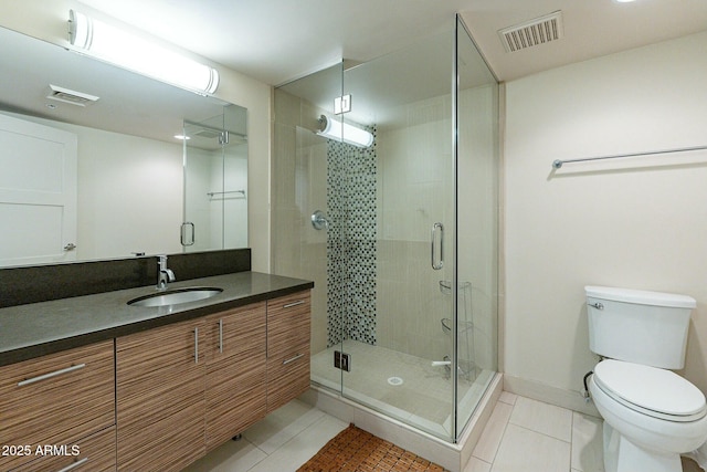 bathroom featuring tile patterned flooring, vanity, walk in shower, and toilet