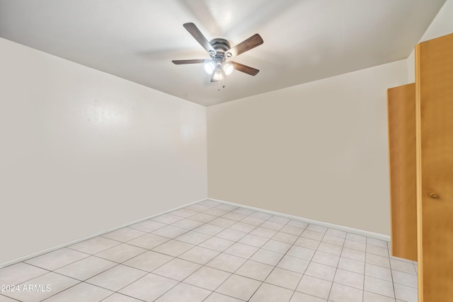 tiled spare room featuring ceiling fan