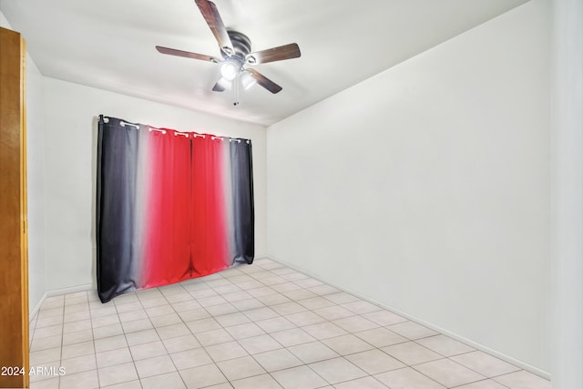 tiled spare room featuring ceiling fan