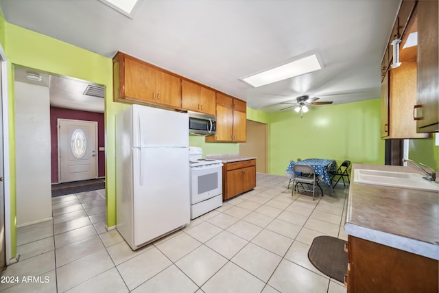 kitchen with light tile patterned flooring, white appliances, ceiling fan, and sink