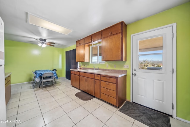 kitchen with ceiling fan, plenty of natural light, light tile patterned floors, and sink