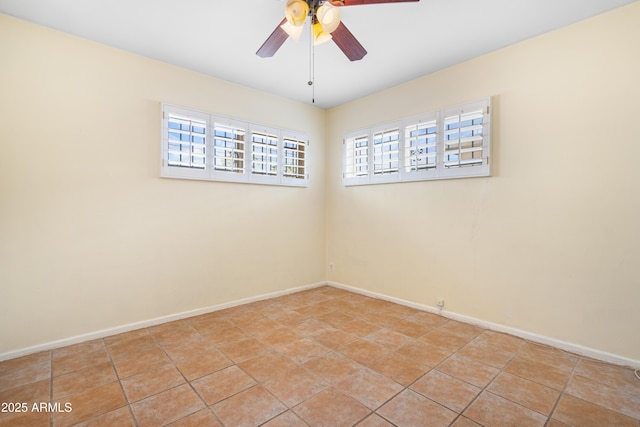 unfurnished room featuring a wealth of natural light, tile patterned floors, baseboards, and a ceiling fan