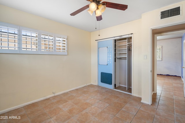 unfurnished bedroom with visible vents, a closet, light tile patterned flooring, baseboards, and ceiling fan