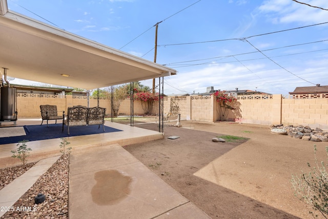 view of patio featuring water heater and a fenced backyard