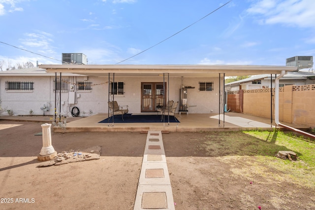 back of house with stucco siding, a patio, fence, french doors, and cooling unit