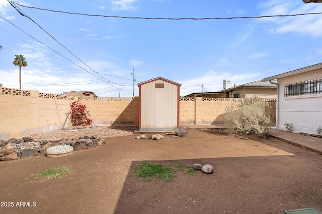 view of yard with an outdoor structure, a storage unit, and a fenced backyard