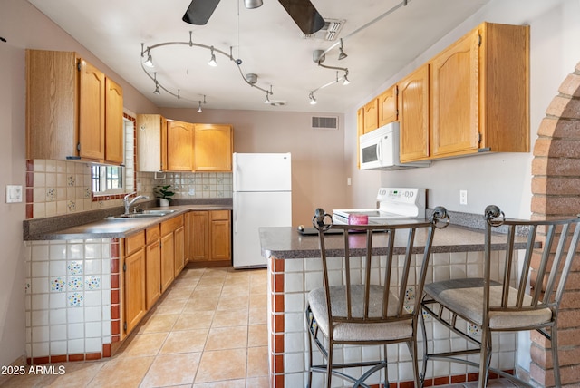 kitchen featuring visible vents, a sink, white appliances, a peninsula, and light tile patterned flooring