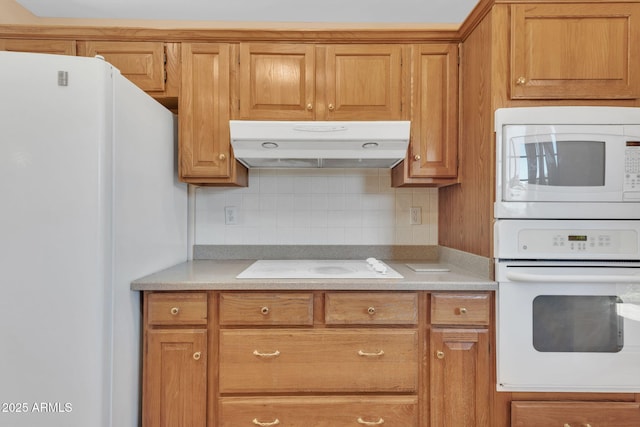 kitchen featuring light countertops, white appliances, decorative backsplash, and under cabinet range hood