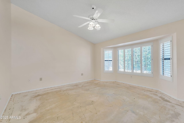 empty room with a ceiling fan, vaulted ceiling, and concrete flooring