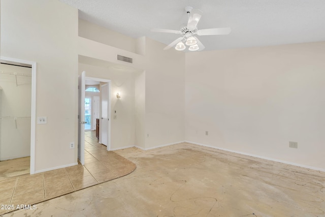 empty room with a ceiling fan, visible vents, and baseboards