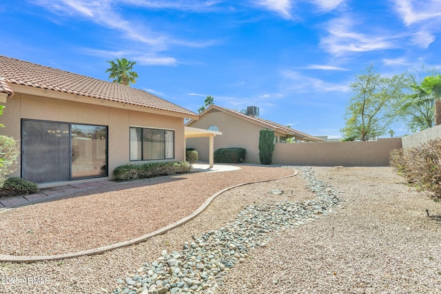 back of house featuring a tiled roof, fence, a patio, and stucco siding