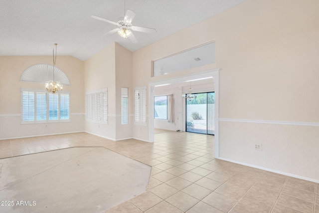 unfurnished room with high vaulted ceiling, tile patterned flooring, baseboards, and ceiling fan with notable chandelier